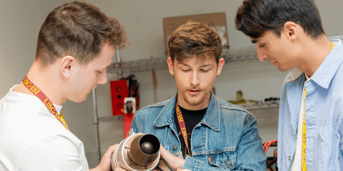 Three scientists examining a robot prototype.